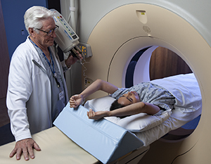 Technician preparing woman for CT scan.